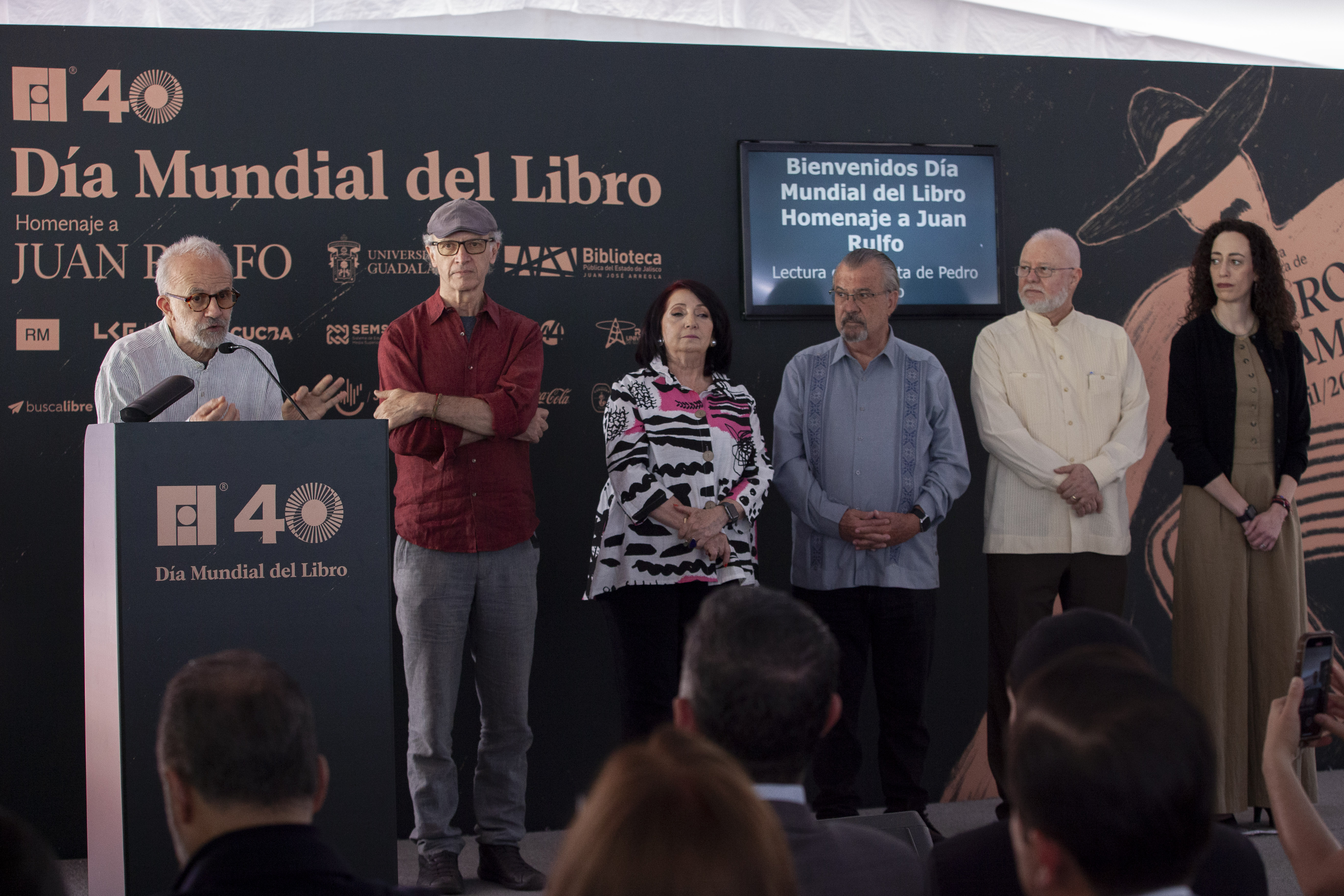 autoridades del evento de pie en escenario